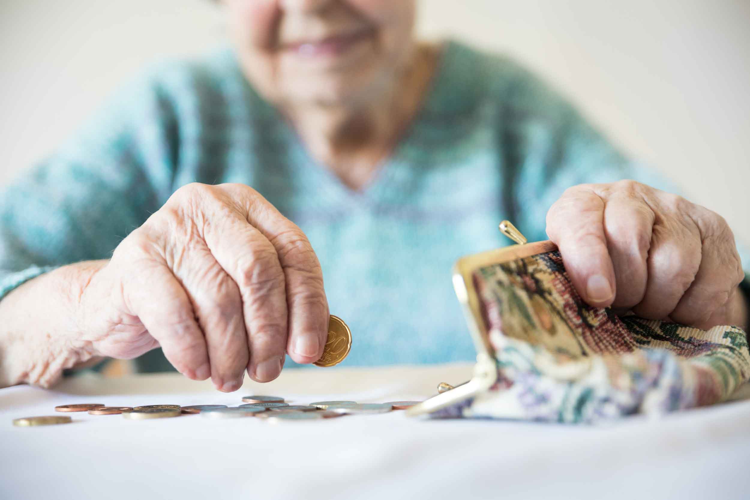 Seniorin zählt das Geld aus ihrer Geldbörse