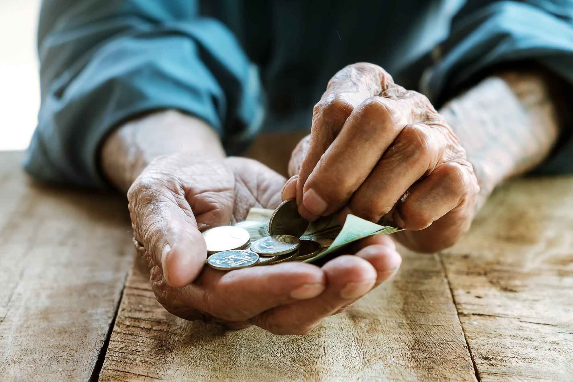 Hände von einem altem Mann mit Geld